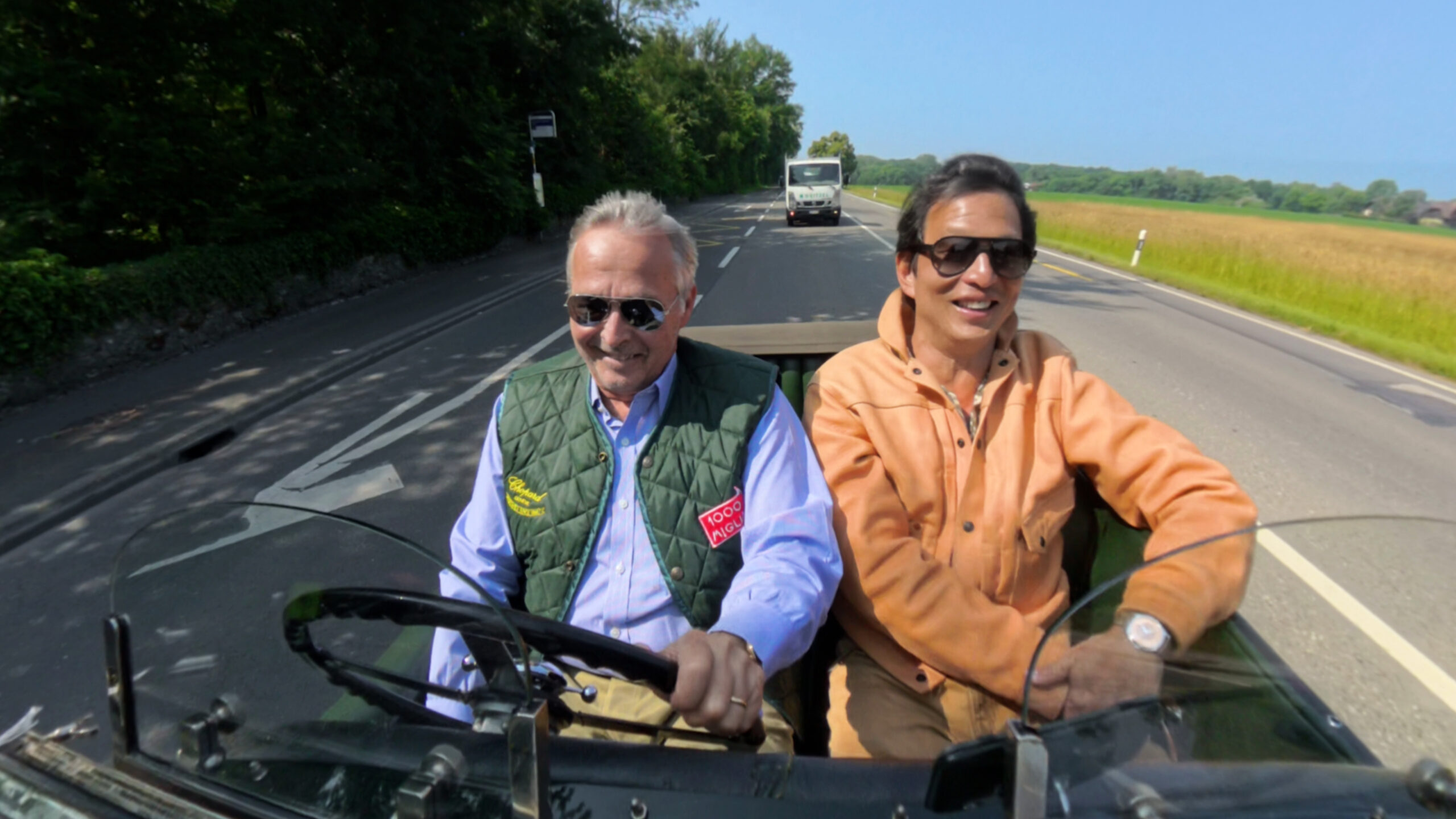 Wei Koh and Karl-Friedrich Scheufele driving in a vintage 1929 Bentley on a sunny road while filming Man of the Hour